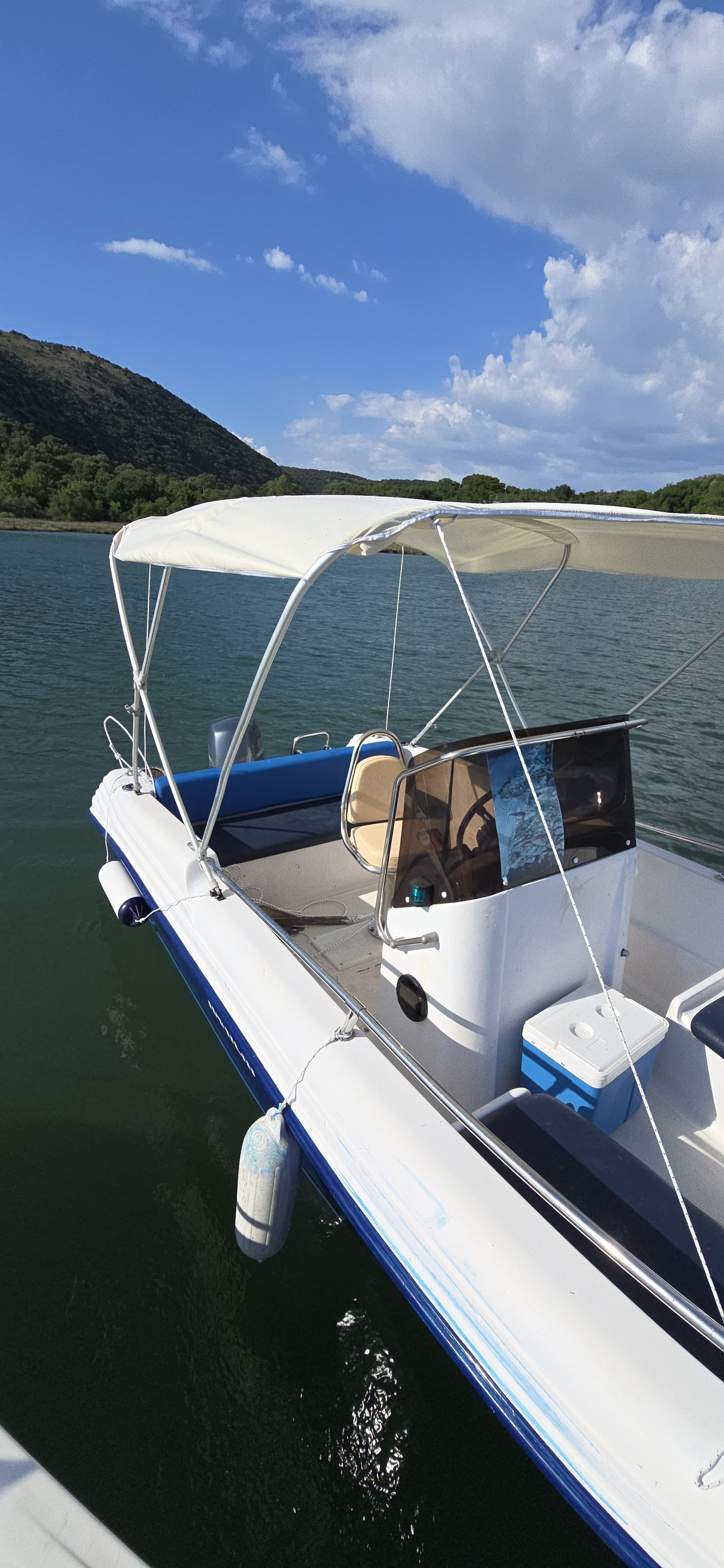 Spacious interior of the Spilada rental boat showing comfortable bow seating, a center console, and a protective sun canopy for relaxing rides