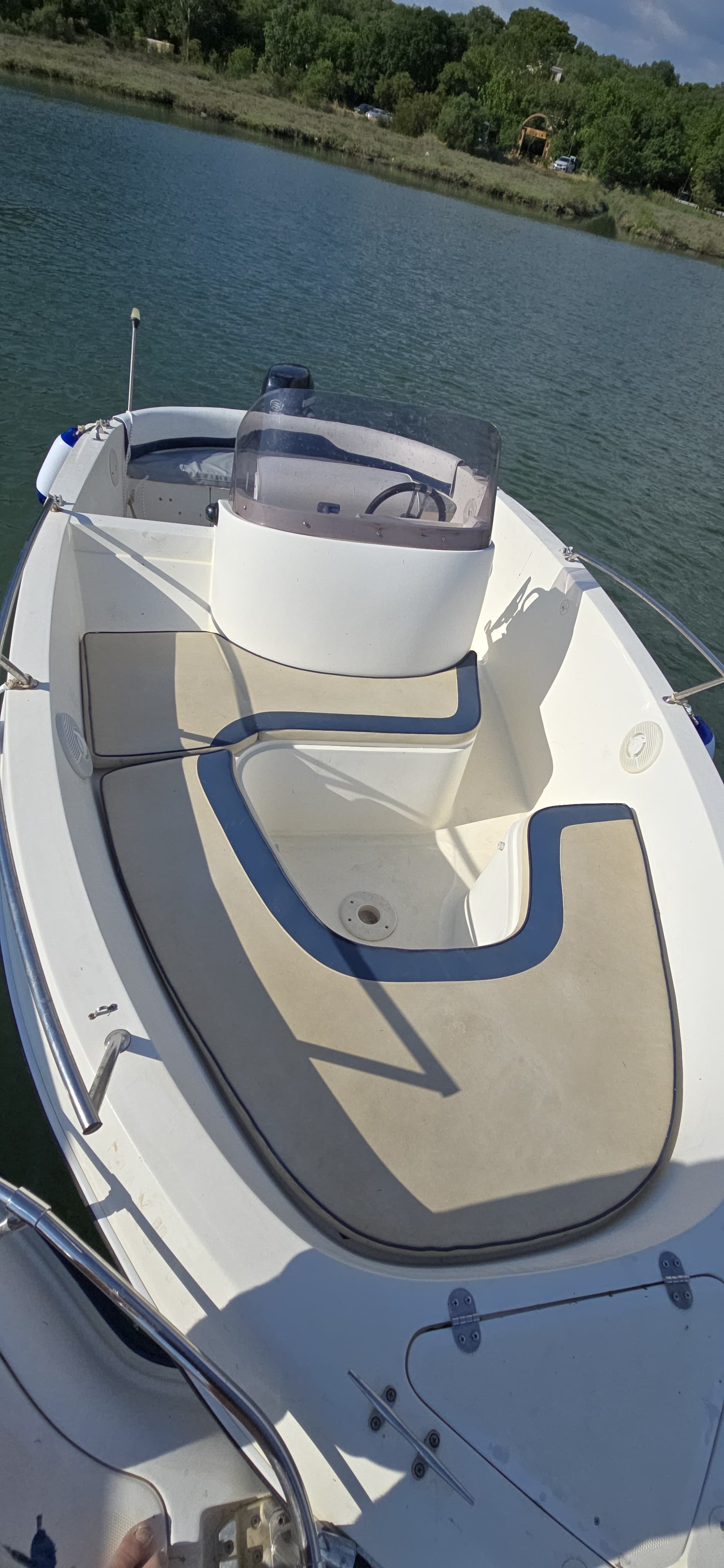 Close-up view of the comfortable front passenger seating area and tinted windshield on the Max 2 self-drive boat