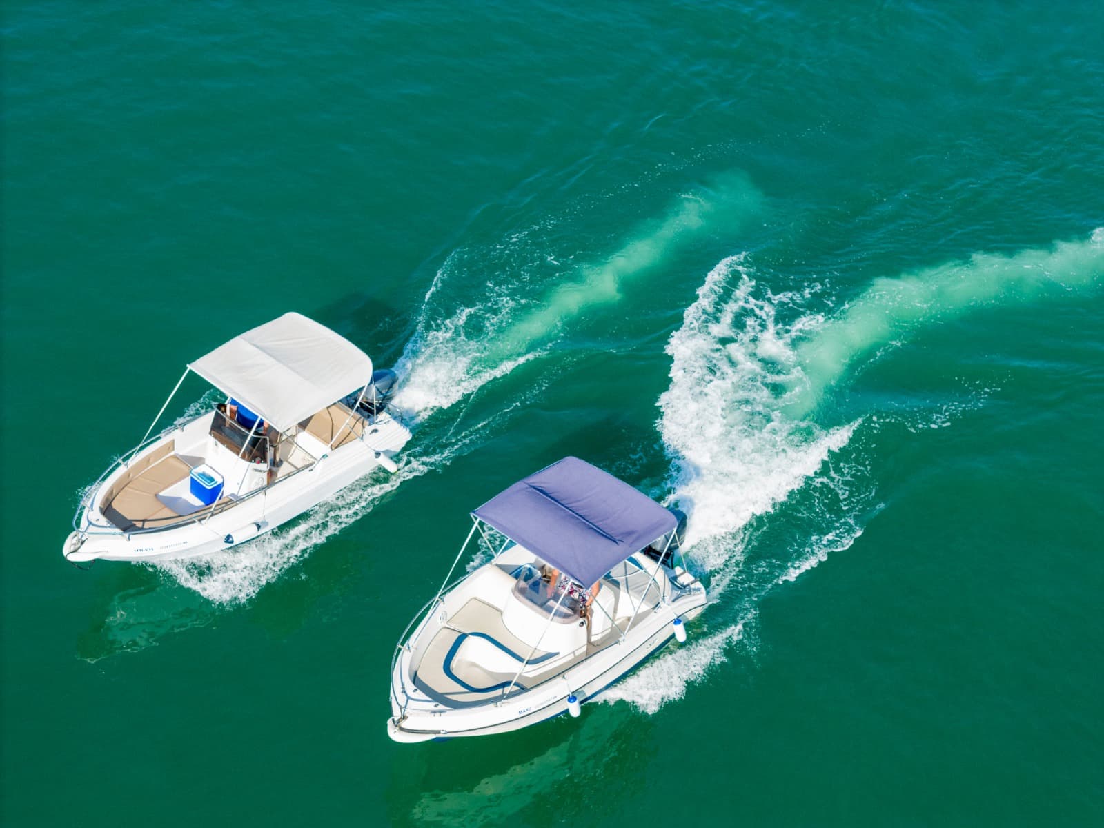 Tourists enjoying a no license boat rental in the beautiful blue waters of Ksamil